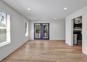 Thumbnail 16 of 28 - a living room with a hardwood floor and a door to a kitchen