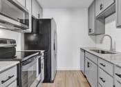 Thumbnail 10 of 28 - an empty kitchen with white cabinets and stainless steel appliances