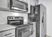Thumbnail 13 of 28 - a kitchen with stainless steel appliances and a refrigerator