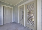 Thumbnail 22 of 28 - the front porch of a home with two windows and a white door