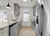 Thumbnail 6 of 28 - an empty kitchen with stainless steel appliances and a counter top