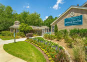 Thumbnail 20 of 34 - a garden in front of a building with a leasing center sign