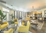 Thumbnail 14 of 25 - a living room with yellow couches and chairs and a kitchen