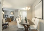 Thumbnail 8 of 25 - a living room and dining room with a table and chairs