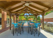 Thumbnail 16 of 25 - a patio with tables and chairs and a grill
