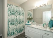 Thumbnail 10 of 25 - a bathroom with a sink and a shower and a mirror