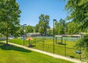 Thumbnail 23 of 25 - a park with a playground and a tennis court