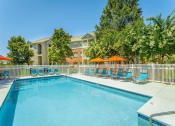 Thumbnail 17 of 25 - a swimming pool with blue chairs and orange umbrellas