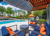 Thumbnail 24 of 35 - a swimming pool with chairs and tables under an umbrella