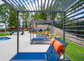 Thumbnail 23 of 35 - an outdoor lounge area with lounge chairs and a pool