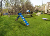 Thumbnail 32 of 35 - a playground with a slide and benches in a park