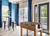 Thumbnail 19 of 35 - a game room with a foosball table and a patio