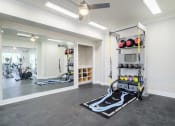 Thumbnail 21 of 35 - a workout room with weights and a treadmill and a ceiling fan