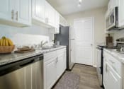 Thumbnail 6 of 35 - a kitchen with white cabinets and a black refrigerator