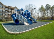 Thumbnail 30 of 35 - a playground with a blue playset in front of an apartment building