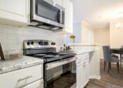 Thumbnail 5 of 35 - a kitchen with a stove and a microwave