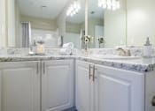 Thumbnail 10 of 35 - a bathroom with white cabinets and a sink and a mirror