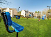 Thumbnail 33 of 35 - a playground with a blue bench in front of an apartment building
