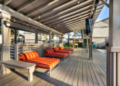 Thumbnail 11 of 24 - poolside covered patio with lounge chairs and TV at Retreat at Brightside Apartments in Baton Rouge, LA
