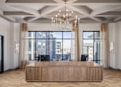 Thumbnail 18 of 22 - A reception area with a wooden desk and a chandelier.