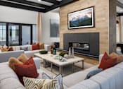 Thumbnail 7 of 22 - A living room with a fireplace and a painting above it.