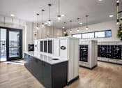 Thumbnail 14 of 22 - A modern kitchen with black and white cabinets and wooden floors.