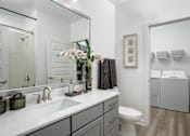 Thumbnail 21 of 22 - A bathroom with a white toilet and a white sink.