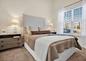 Thumbnail 13 of 55 - A Model Bedroom with a large bed and two lamps on either side of the bed displaying the size of the bedroom and the height of the ceiling.