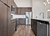 Thumbnail 52 of 55 - A modern kitchen with dark wood cabinets and stainless steel appliances.