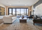 Thumbnail 37 of 55 - a living room with a white couch and a table and a balcony at Artisan Flats in Birmingham, AL