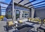 Thumbnail 21 of 55 - rooftop balcony with chairs and a table and a view of the city at Artisan Flats Apartments in Birmingham, AL