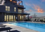 Thumbnail 28 of 55 - Twilight Pool View with Soft Seating at Artisan Flats Apartments in Birmingham, AL