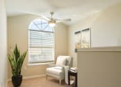 Thumbnail 34 of 34 - a living room with a ceiling fan and a chair