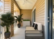 Thumbnail 23 of 34 - a covered porch with a couch and palm trees