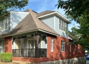 Thumbnail 28 of 28 - a red brick house with a porch and a black railing