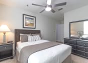Thumbnail 8 of 25 - a bedroom with a large bed and a ceiling fan