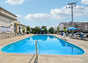 Thumbnail 20 of 21 - A large outdoor swimming pool with a diving board.