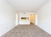 Thumbnail 10 of 19 - A large, empty room with a carpeted floor and white walls.