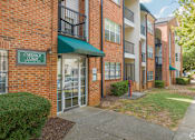 Thumbnail 5 of 19 - The image shows a brick building with a green awning and a sign that reads "Cadence Court."