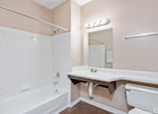 Thumbnail 18 of 19 - A bathroom with a white tub and sink.