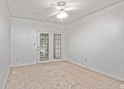 Thumbnail 16 of 19 - A room with a ceiling fan and a door with a window.
