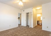 Thumbnail 11 of 19 - A room with a ceiling fan and carpeted floor.