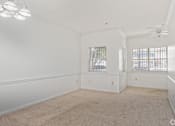 Thumbnail 15 of 19 - A spacious room with a carpeted floor and a ceiling fan.