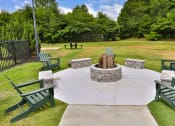 Thumbnail 24 of 25 - a fire pit in the middle of a yard with chairs around it