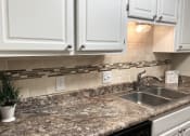 Thumbnail 5 of 32 - White kitchen cabinets and granite countertops at Malibu at Martin Apartments in Huntsville, Alabama