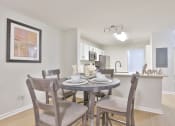 Thumbnail 6 of 25 - a dining room and kitchen with a table and chairs