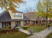 Thumbnail 23 of 28 - a woman walking down a sidewalk in front of a row of houses