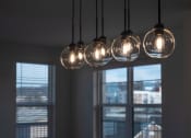 Thumbnail 53 of 55 - a row of lights hanging from a ceiling with windows at Artisan Flats in Birmingham, AL