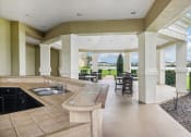 Thumbnail 26 of 33 - a large porch with a sink and a patio with tables and chairs
