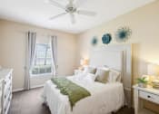 Thumbnail 6 of 33 - a bedroom with a bed and a ceiling fan